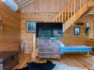 un salon avec une grande télévision dans une cabane en rondins dans l'établissement Holiday Home Hietaniemen usko by Interhome, à Sonkajärvi