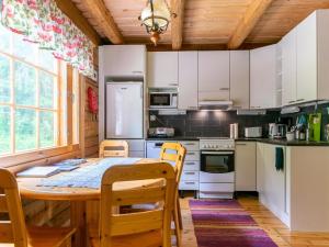 une cuisine avec des armoires blanches et une table et des chaises dans l'établissement Holiday Home Hietaniemen usko by Interhome, à Sonkajärvi 17 autres photos