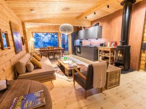 ein Wohnzimmer mit einem Kamin in einem Blockhaus in der Unterkunft Holiday Home Kelokaltiokylän maja 22 by Interhome in Rukatunturi 
