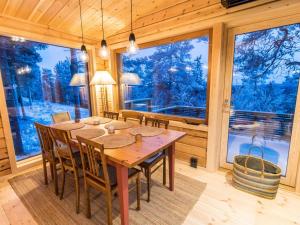 ein Esszimmer mit Tisch und Stühlen und einem großen Fenster in der Unterkunft Holiday Home Kelokaltiokylän maja 22 by Interhome in Rukatunturi 