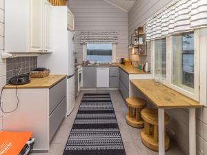 a kitchen with white cabinets and a table and benches at Holiday Home Onnimanni by Interhome in Kuusamo