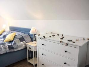 een slaapkamer met een wit dressoir en een bed bij Holiday Home Lakeside Village 47 by Interhome in Frymburk