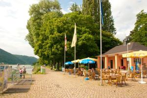 a street with tables and chairs and umbrellas at Neubert`s Gasthaus am Rhein in Lahnstein