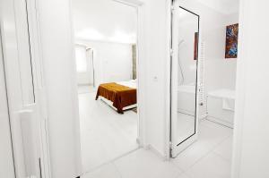 a white room with a mirror and a bed at Danube Residence in Galaţi +64 photos
