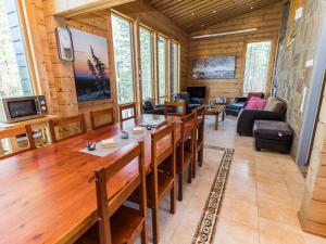a living room with a large wooden table and chairs at Holiday Home Matkajoentie 4b by Interhome in Kuusamo