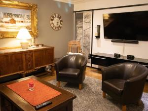 a living room with two chairs and a flat screen tv at Holiday Home Villa meka by Interhome in Sastamala