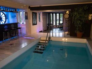 a swimming pool with a bar and a clock at Holiday Home Villa meka by Interhome in Sastamala