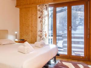 Duas camas num quarto com vista para uma varanda em Apartment Bietschorn 22 by Interhome em Nendaz
