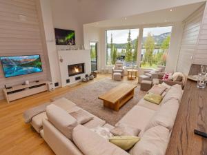 ein Wohnzimmer mit einem großen Sofa und einem Kamin in der Unterkunft Holiday Home Holy lake chalet a by Interhome in Kuusamo