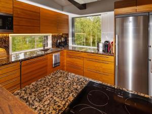 eine Küche mit Holzschränken und einem Edelstahlkühlschrank in der Unterkunft Holiday Home Holy lake chalet a by Interhome in Kuusamo
