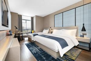 Ένα ή περισσότερα κρεβάτια σε δωμάτιο στο Echarm Hotel - Jingmen Yintai City Jingchu Institute of Technology