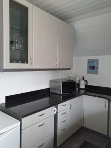 a kitchen with white cabinets and a black counter top at Koblenz Asterstein Ferienwohnung in Koblenz +11 photos