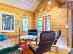 una baita di tronchi con soggiorno dotato di tavolo e sedie di Holiday Home Strandkulla 7 by Interhome a Närpiö