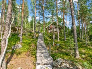 een houten pad dat leidt naar een hut in het bos bij Holiday Home Karhupirtti by Interhome in Mäntyharju