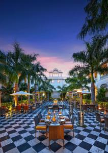 un resort con tavoli, sedie e palme di The Tigress, Ranthambore a Sawai Madhopur
