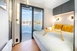a bedroom with a bed and a table with a view of the water at The Homeboat Company Albufeira in Albufeira