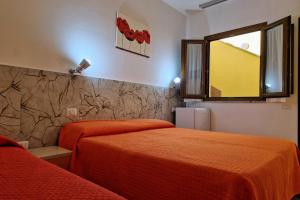 a bedroom with two beds and a window at Sa Mamma e Sole in Cala Gonone +18 photos