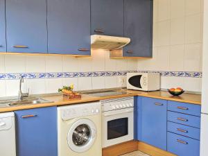 kuchnia z niebieskimi szafkami i pralką w obiekcie Holiday Home La Almadraba by Interhome w mieście Carrer del Mar