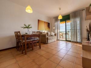 Una sala de estar con una mesa y sillas y un sofá. en Apartment Paola by Interhome, en L'Eucaliptus