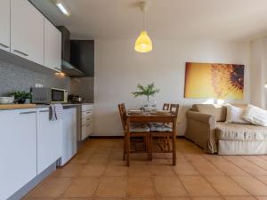 Una cocina y una sala de estar con una mesa y un sofá. en Apartment Paola by Interhome, en L'Eucaliptus