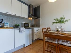 cocina con armarios blancos, mesa de madera y comedor en Apartment Paola by Interhome, en L'Eucaliptus 19 fotos más