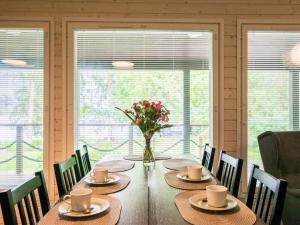 ein Esszimmer mit einem Tisch mit einer Vase mit Blumen in der Unterkunft Holiday Home Villa vehmas by Interhome in Sysmä