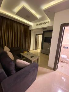 un salon avec un canapé et une table dans l'établissement abdoun rooftop 1bedroom kh&sh 04, à Amman