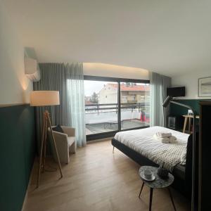 a bedroom with a bed and a large window at Vila Camélia in Porto