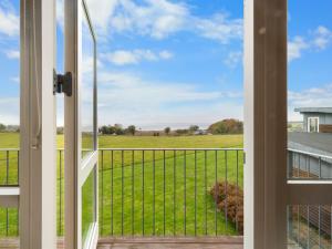an open door to a view of a field from a porch at Holiday Home Krum - 300m from the sea by Interhome in Nabbe
