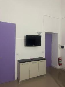 トリノにあるAngolo di Violaの壁にテレビとテーブルが備わる客室です。