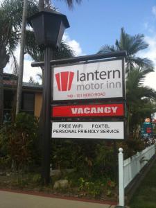 a sign for a motor inn next to a street light at Lantern Motor Inn in Mackay