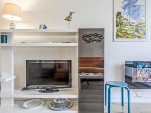 a living room with a tv and a blue stool at Apartment Le Zal-4 by Interhome in Quiberon +16 photos