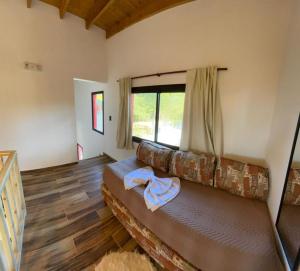 a living room with a couch and a window at Cabaña La Arianna in Santa Teresita