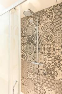 a shower in a bathroom with a tile wall at Herberg de Geulhemermolen in Berg en Terblijt