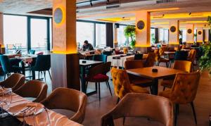 a restaurant with tables and chairs and a person in the background at Gold Apartments Kopaonik in Kopaonik