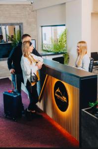 a man and a woman standing next to a desk at Gold Apartments Kopaonik in Kopaonik +17 photos