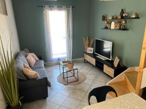 salon z kanapą i telewizorem w obiekcie la maison des sables 4 port Leucate climatisé parking privé w mieście Port Leucate