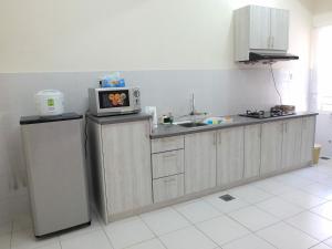 a kitchen with a microwave on top of a refrigerator at Dillenia Nilai Homestay in Nilai