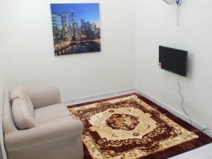 salon z kanapą i telewizorem w obiekcie Dillenia Nilai Homestay w mieście Nilai