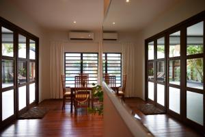 a dining room with a table and chairs and windows at Tropical Villa Rainville in Paramaribo