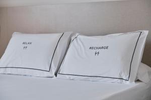 two white pillows sitting on top of a bed at Helios Benidorm in Benidorm