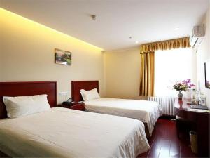 A bed or beds in a room at GreenTree Inn ShanXi LuLiang FengShan Road Central Park Express Hotel