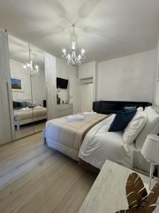 a bedroom with a large bed and a chandelier at Palazzo Monterone Apartments in Spoleto