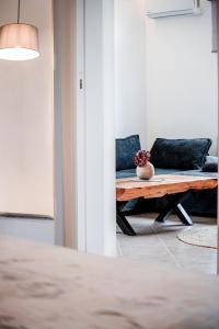 Noho Villas @ Sunlit house Paros في Nea Cryssi Akti: غرفة معيشة مع أريكة وطاولة