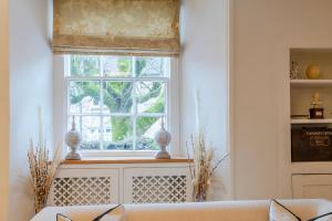 a living room with a couch and a window at Antelope Cottage in Northleach