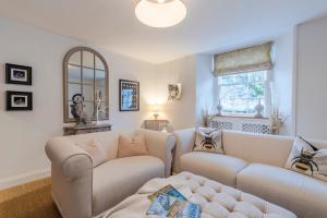 a living room with two couches and a window at Antelope Cottage in Northleach