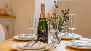 a bottle of champagne sitting on a table with glasses at Antelope Cottage in Northleach