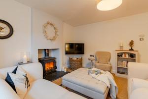 a living room with a couch and a fireplace at Antelope Cottage in Northleach