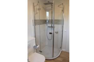 una doccia con una porta in vetro in un bagno di LITZKOW 11208 a Morsum
