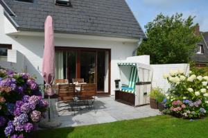 un patio con tavolo, sedie e fiori di LITZKOW 11208 a Morsum